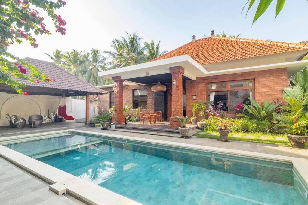 una casa con piscina frente a una casa en Dani Vila, 2BR, Pool, enclosed kitchen and living area at Buleleng, North Bali, en Gretek