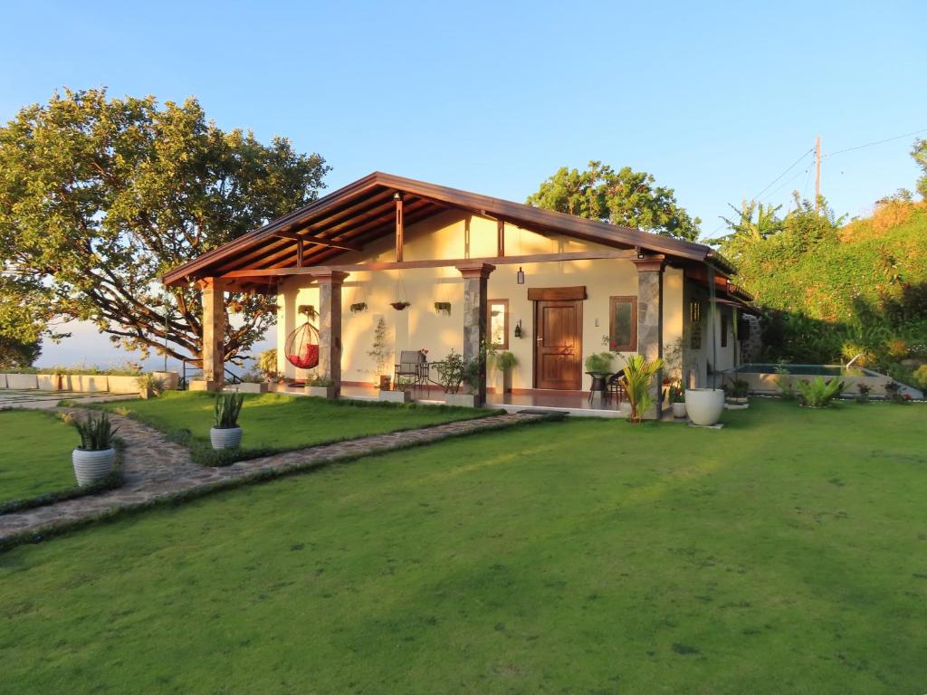 una casa con un césped verde delante de ella en Hapu Tales - Private Holiday Villa en Haputale