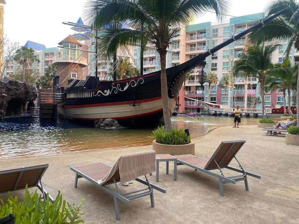um barco na água com duas cadeiras e uma mesa em Grand Caribbean Condo Resort Pattaya swimming pool balcony em South Pattaya