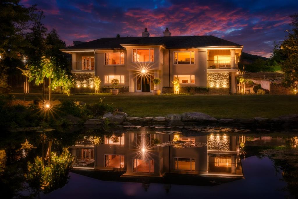 uma casa iluminada à noite com luzes na água em Oakview em Hanmer Springs