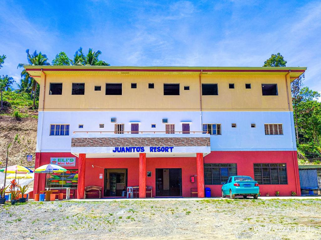 TangalanにあるJuanito's Resortの青い車が目の前に停まっている建物