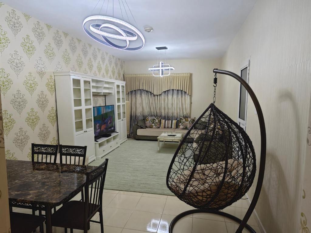 a living room with a table and chairs and a couch at Orient Perl Apartment in Ajman 
