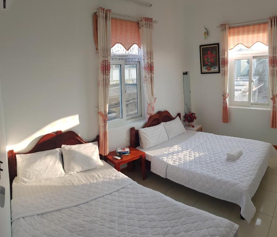 dwa łóżka w pokoju z dwoma oknami w obiekcie Ly Tri Ly Son Hotel w mieście Ly Son