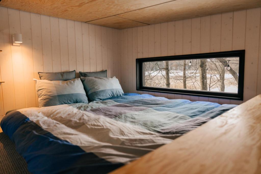 a large bed in a room with a window at Living art piece at the lake. 
