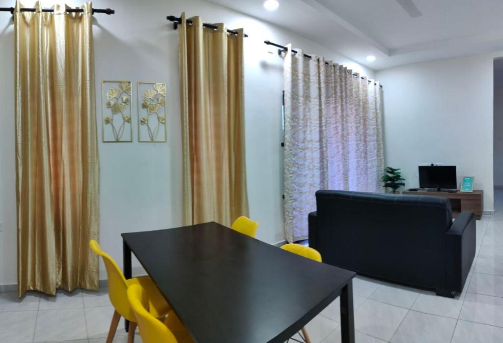 Homestay HABI Residence في Kepala Batas: غرفة طعام مع طاولة سوداء وكراسي صفراء