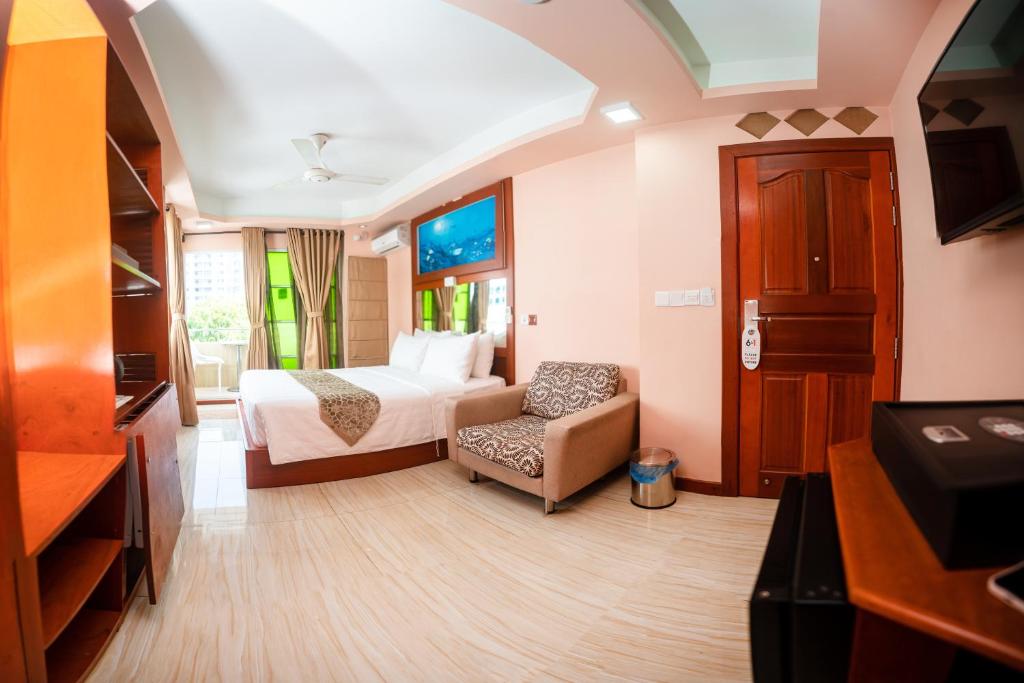 une chambre d'hôtel avec un lit et une chaise dans l'établissement ZAN Lodge, à Malé