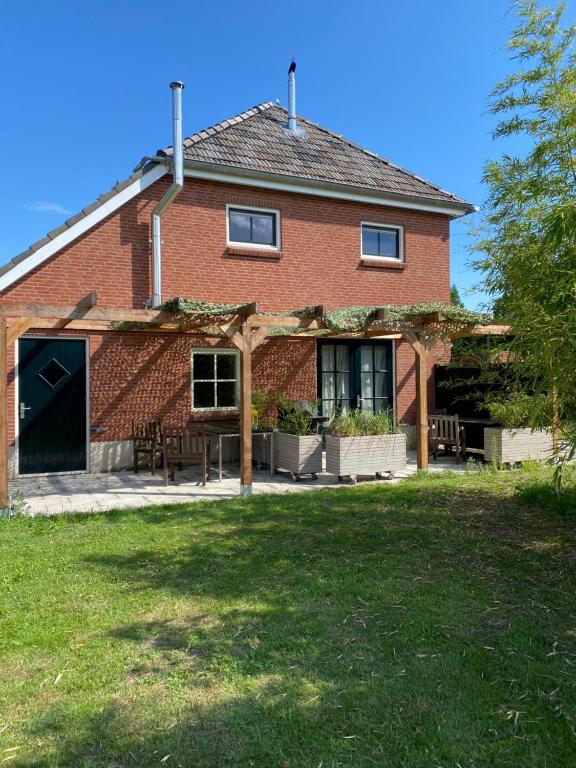 a red brick house with an open garage at Heerlijk Gaanderhei in Gaanderen