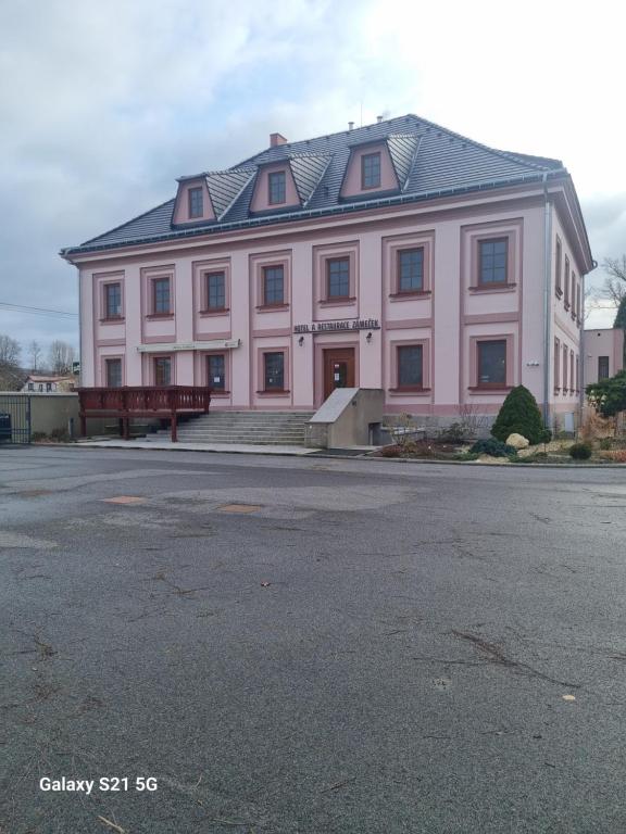 un gran edificio rosa con techo negro en Hotel Zámeček Raspenava en Raspenava