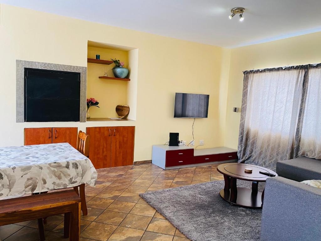 a bedroom with a bed and a tv and a couch at Third Haven in Swakopmund