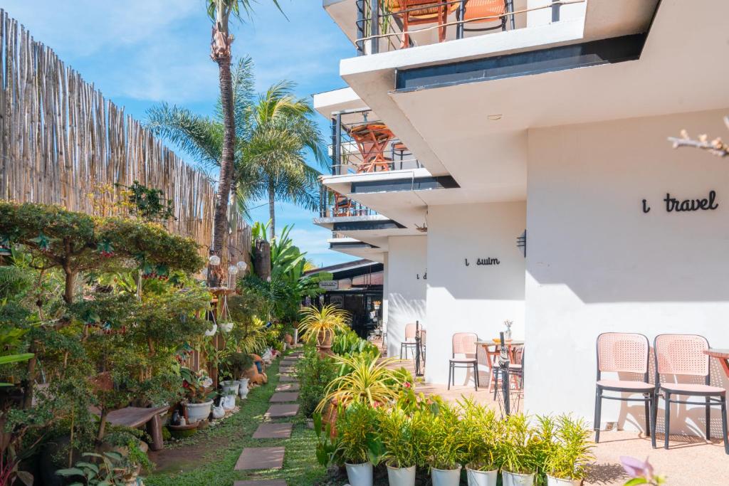 een gebouw met tafels, stoelen en planten bij Bay Area Lodge in Coron