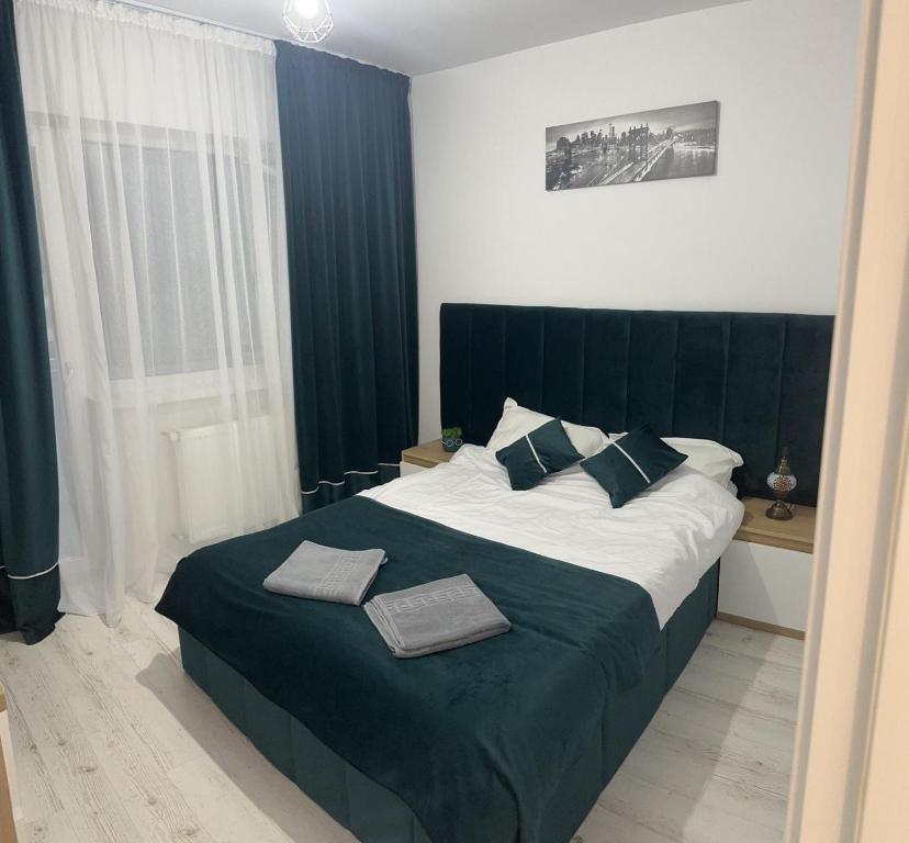 a bedroom with a large bed with a black headboard at Studio - Cozy Home Slatina in Slatina