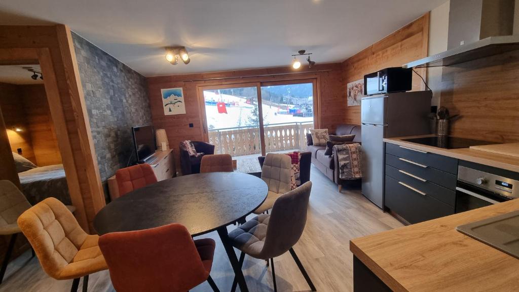 eine Küche mit einem Tisch und Stühlen im Zimmer in der Unterkunft L'Étoile du Linga in Châtel