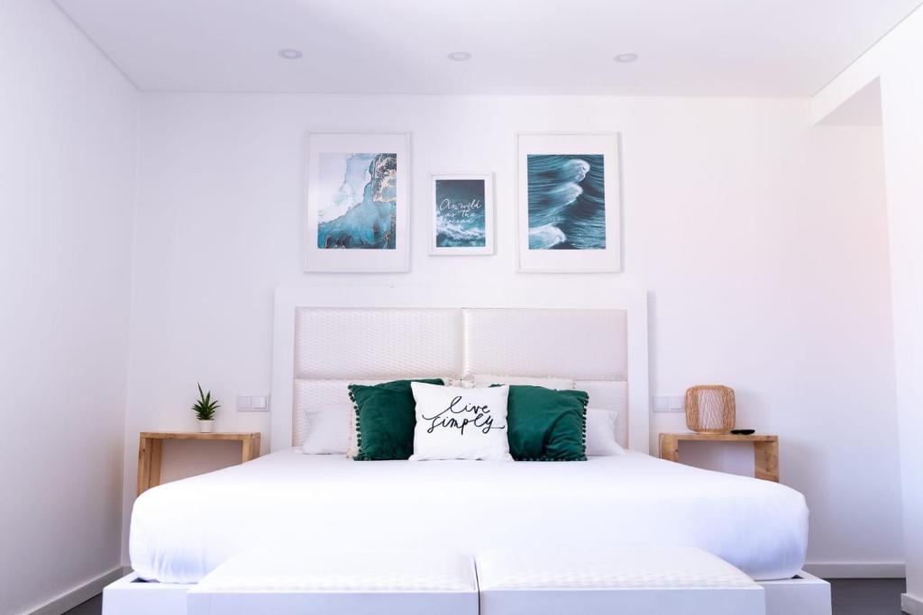 biała sypialnia z białym łóżkiem z zielonymi akcentami w obiekcie SUPERTUBOS HOUSE Peniche w mieście Peniche