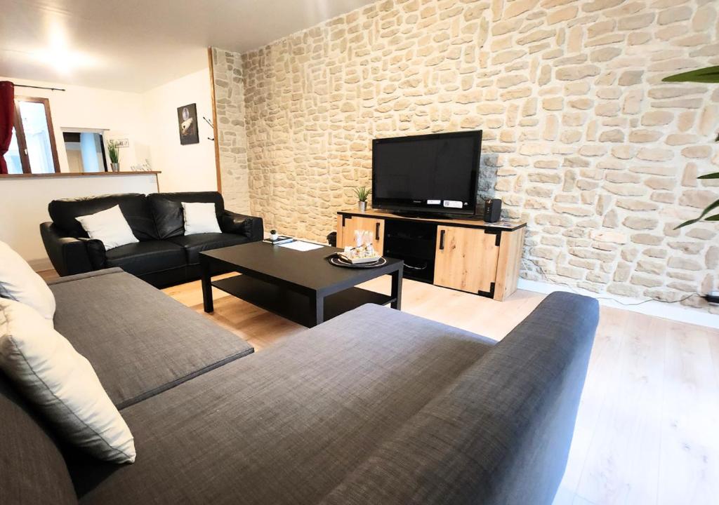 a living room with a couch and a tv at "Colbert Triplex" 3 chambres - Balcon - Patio - Cathédrale in Tours