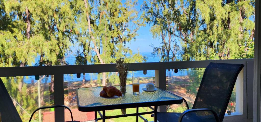 Una mesa y sillas en un balcón con vista. en Phoenix Beach Apartments sea view, en Flic en Flac