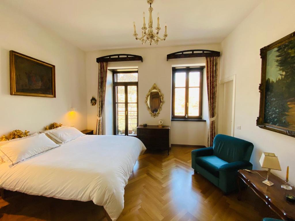 a bedroom with a large bed and a blue chair at Casa Daniela in Trento