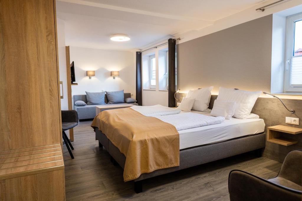 une chambre d'hôtel avec un lit et un canapé dans l'établissement Balkes Morhoff, à Petershagen