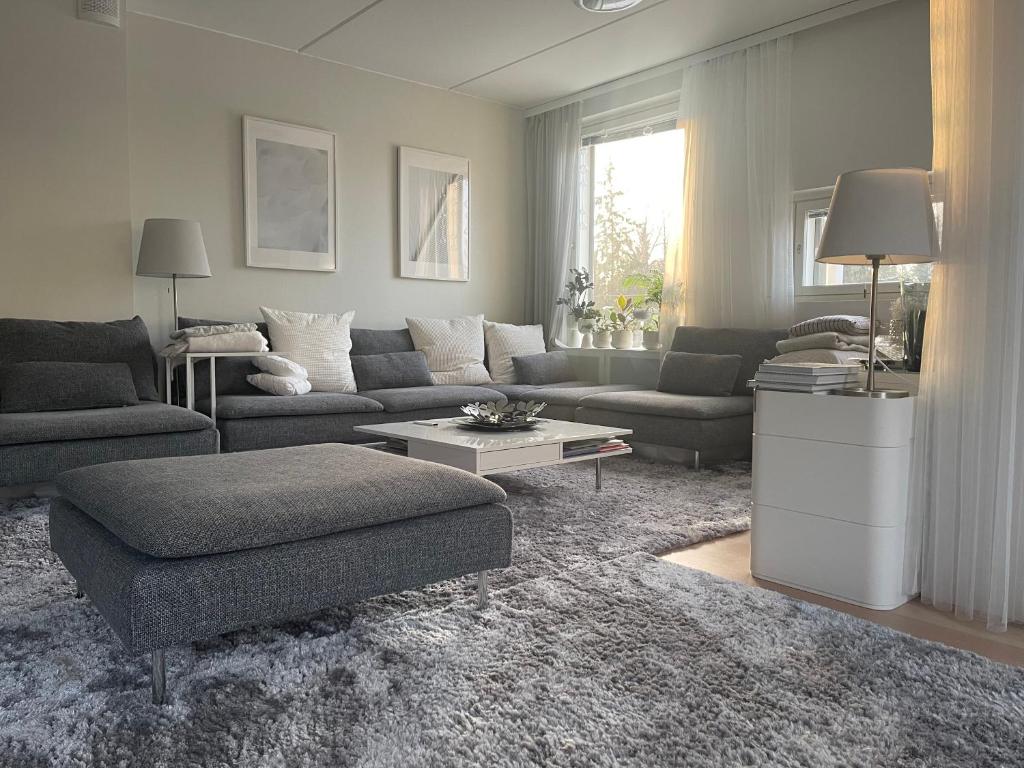 uma sala de estar com um sofá e uma mesa em Upea 117,5m2 huoneisto Helsingin keskustassa em Helsinque