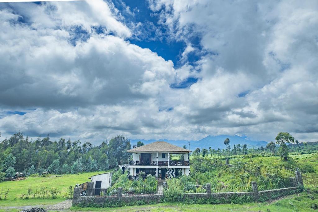 uma casa numa colina num campo em Kinigi Cottage em Kinigi