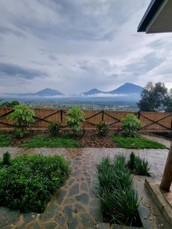 a garden with a fence and mountains in the background at Khaya Nzuri 