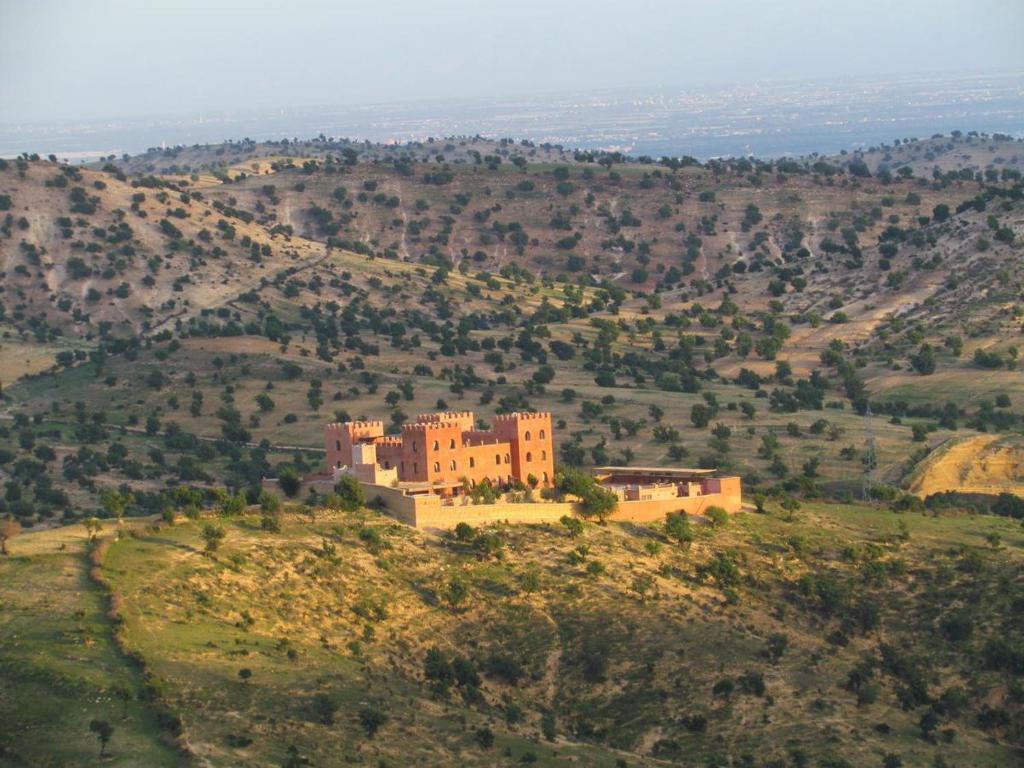 un gran edificio en una colina en un campo en Ecolodge Atlas Kasbah, en Agadir