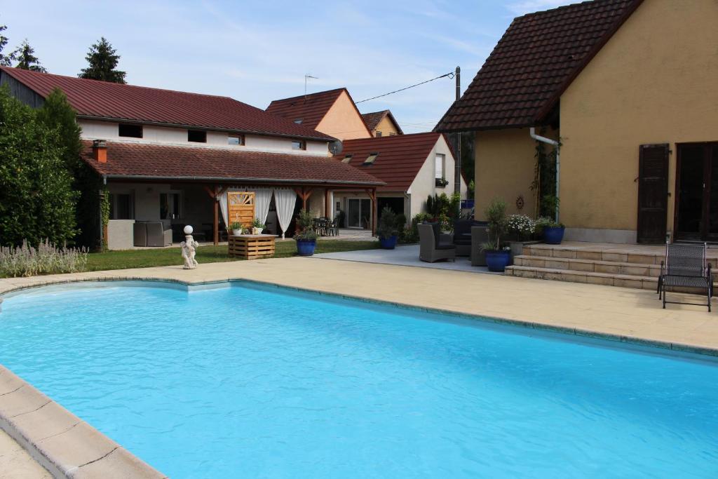 a swimming pool in front of a house at Appartement Studio Agrita in Wittisheim