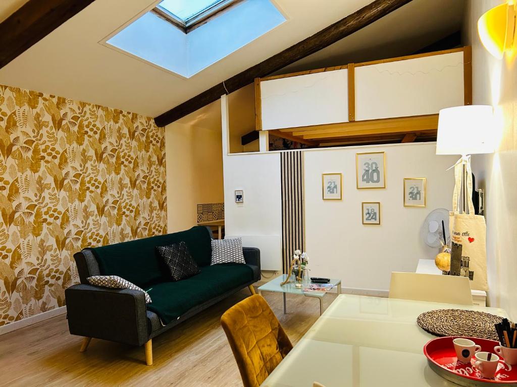 un salon avec un canapé vert et une table dans l'établissement Le Saint-Lazare appartement au calme intra muros, à Avignon