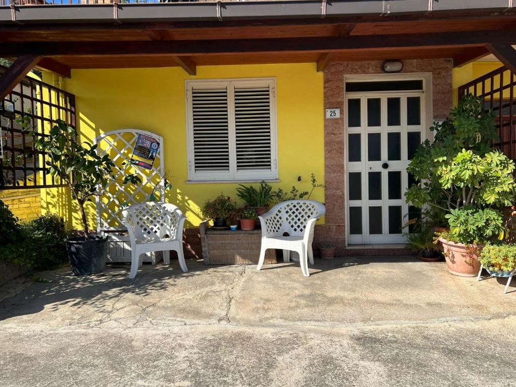 twee stoelen voor een geel huis bij Villa Angelina holidays in Ripa Teatina