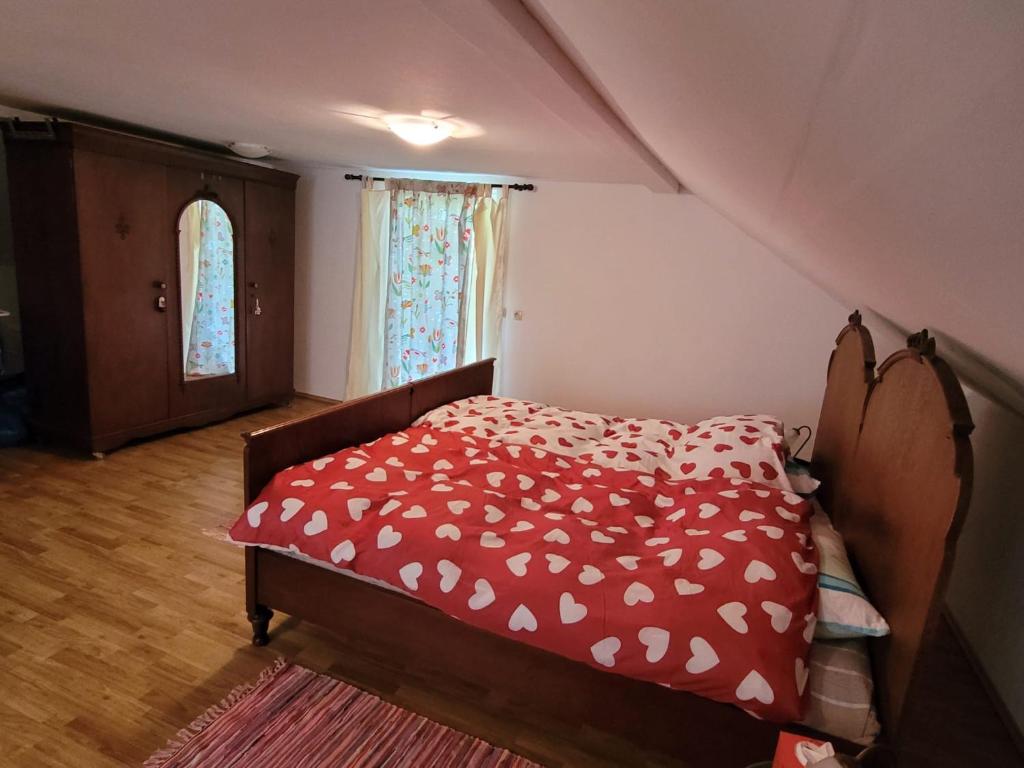 a bedroom with a bed with a red comforter at Landhaus Kate in Lusnić