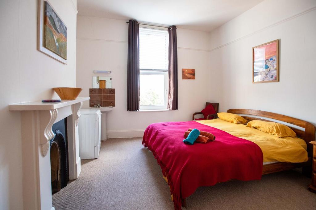um quarto com uma cama com um cobertor vermelho em Bright, character 3 bed Apartment: 7 mins walk to sea em Portsmouth