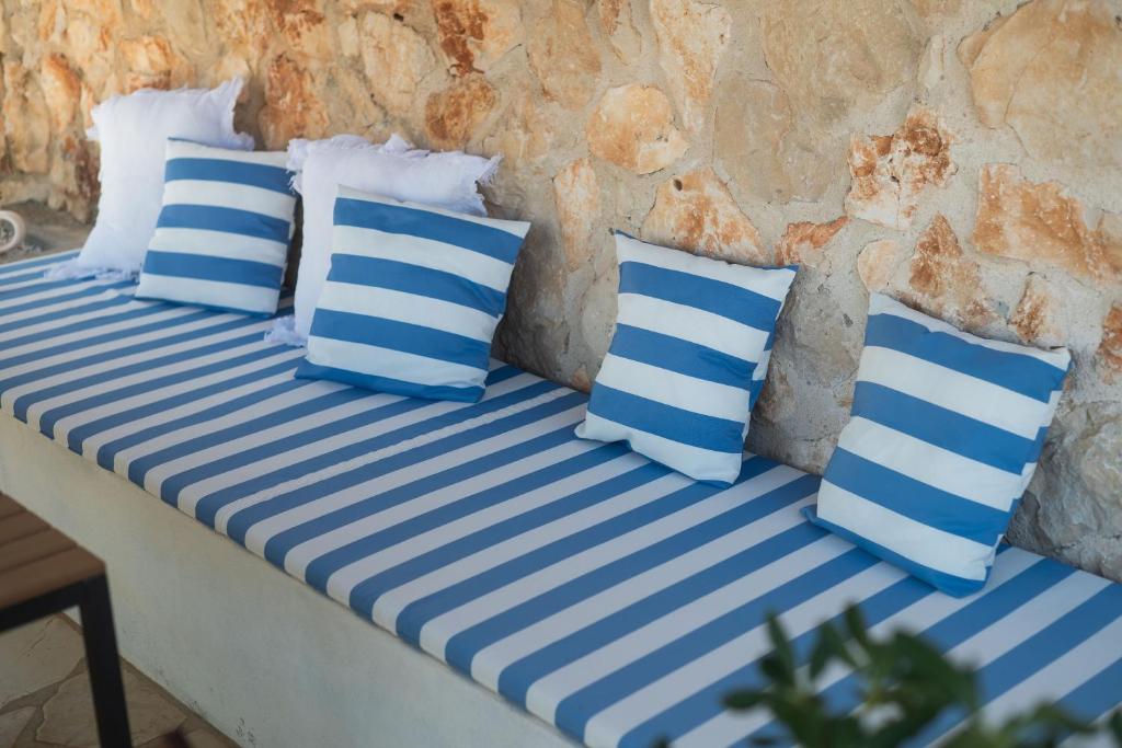 4 almohadas azules y blancas sentadas en una cama en Villa Gjardini - Sparadici, en Grebaštica