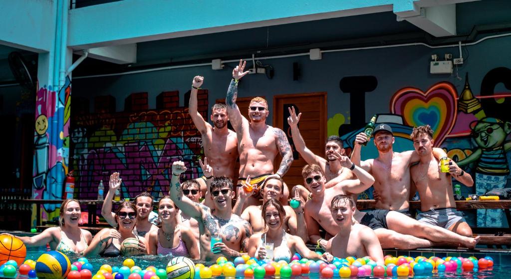 un gruppo di uomini che posano per una foto in piscina di Mad Monkey Chiang Mai a Chiang Mai