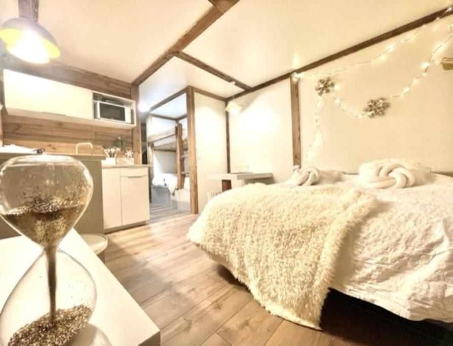 a bedroom with a bed and a table with a clock at New, terrasse, vue Mont Blanc in Chamonix-Mont-Blanc