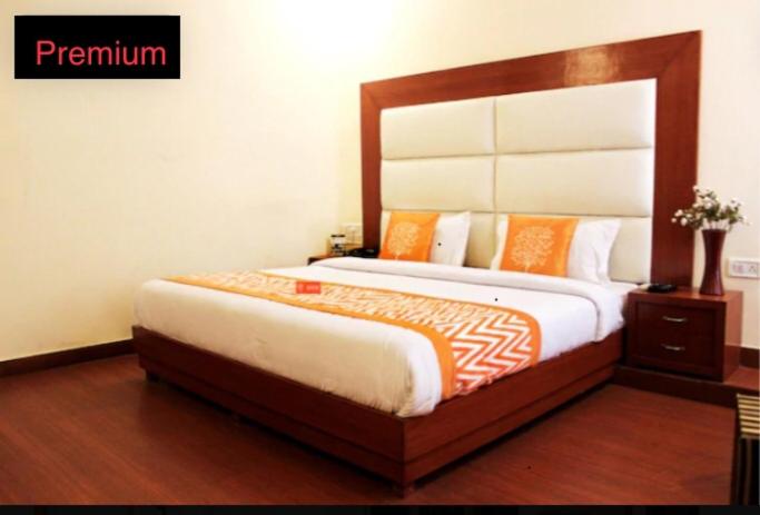 a bedroom with a large bed with a wooden headboard at hotel dreamland in Haridwār