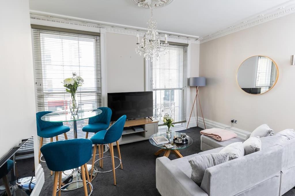 a living room with a couch and blue chairs at Stunning 2 Bed in the Centre of Cheltenham! in Cheltenham