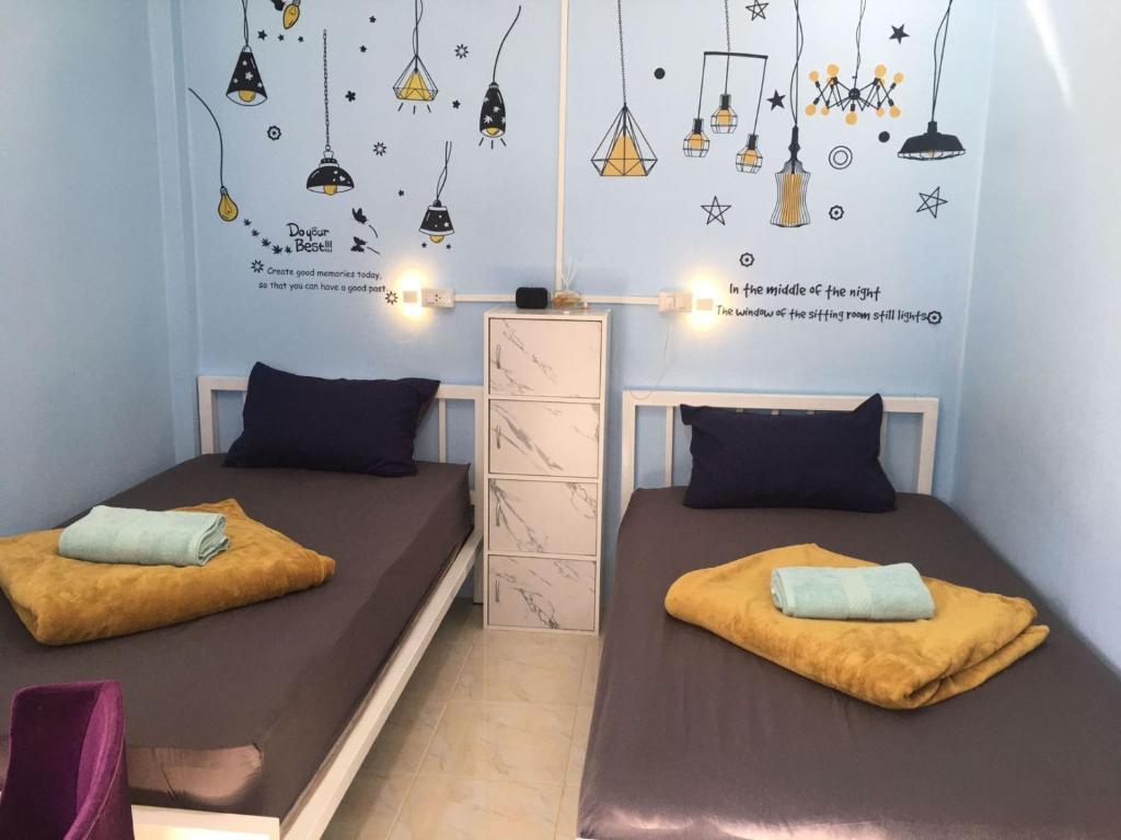 World Citizen GuestHouse في كو بانغان: سريرين في غرفة صغيرة مع أضواء