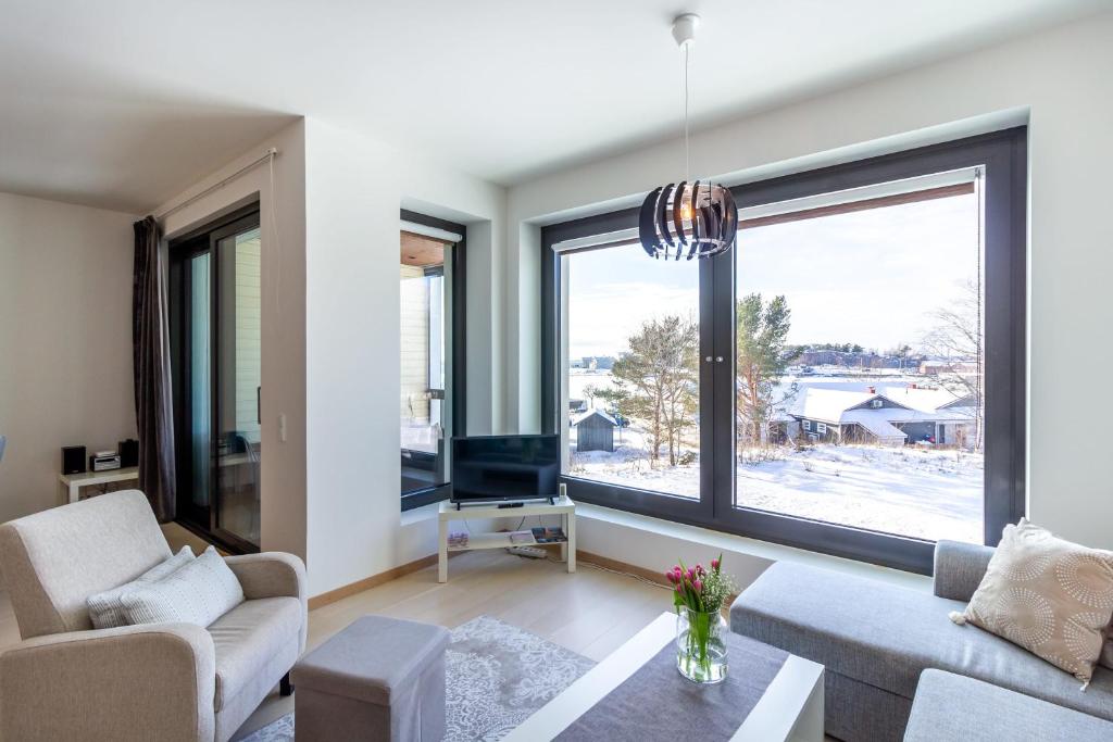 a living room with a couch and a large window at Regatta Seaside Suite in Hanko in Hanko