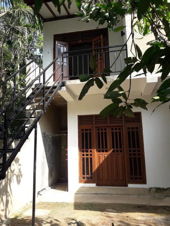 a building with a staircase and a wooden door at Harmonic villa in Weligama