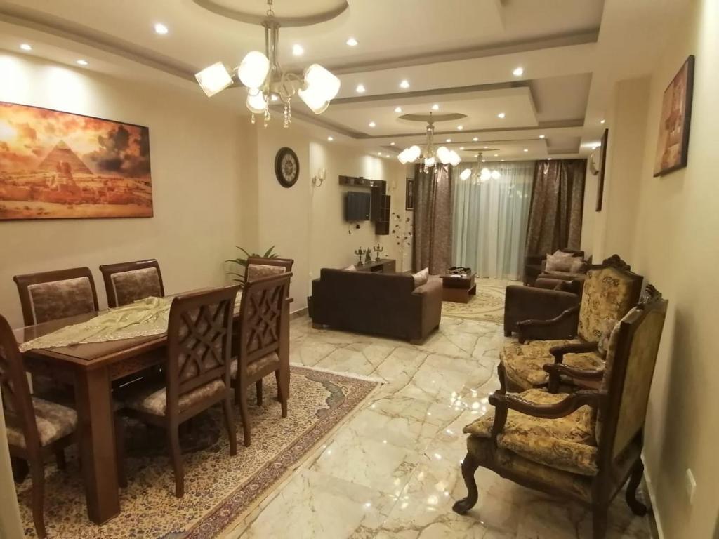 a living room with a table and chairs and a couch at شقه فندقيه مواجهه للأهرامات. Hotel Apartment in Cairo