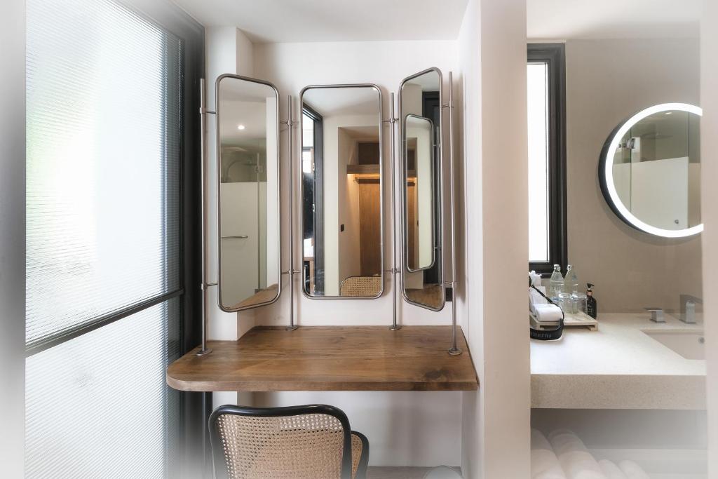 une salle de bains avec 4 miroirs sur une étagère en bois dans l'établissement Baan Haad Ngam Boutique Resort, à Chaweng