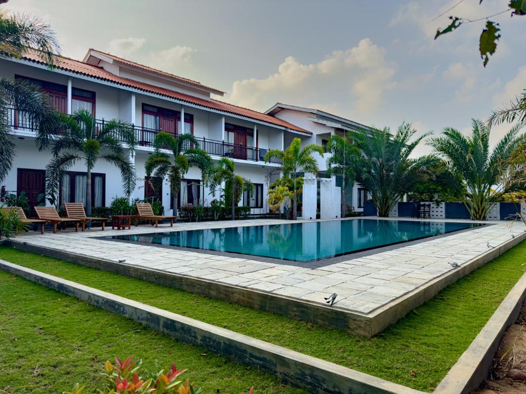 una imagen de una piscina frente a un edificio en The Reef Resort, en Nilaveli