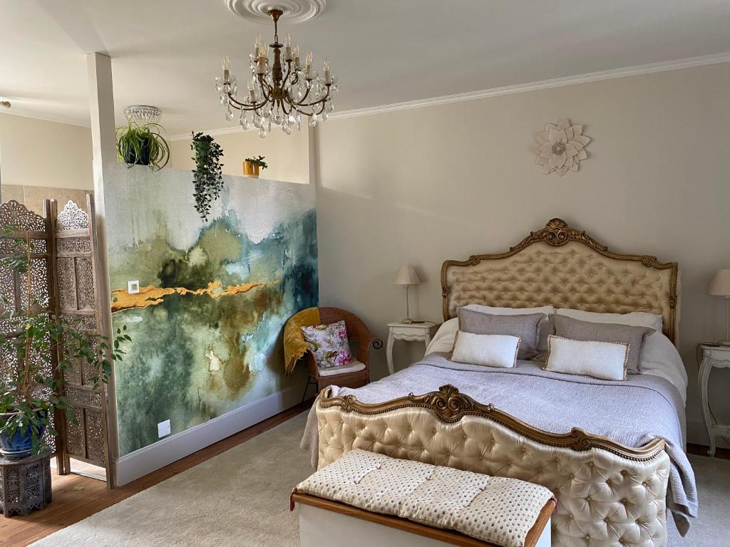 ein Schlafzimmer mit einem Bett und einem Wandgemälde in der Unterkunft La Maison 64 Chambre D'Hôtes in Barbaste
