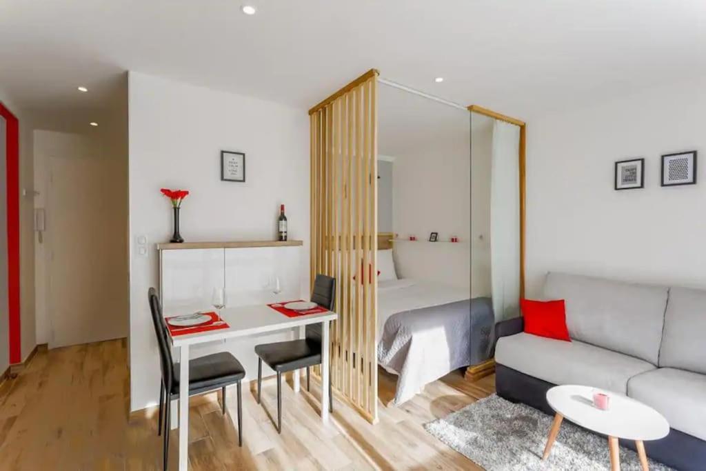 Cette petite chambre comprend un lit, une table et un canapé. dans l'établissement Palais Lilou - Studio Central 300 m des plages, au calme, à Cannes
