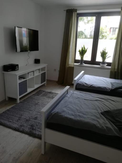 a bedroom with a bed and a flat screen tv at Appartment, gemütlich u. zentral in Hattingen