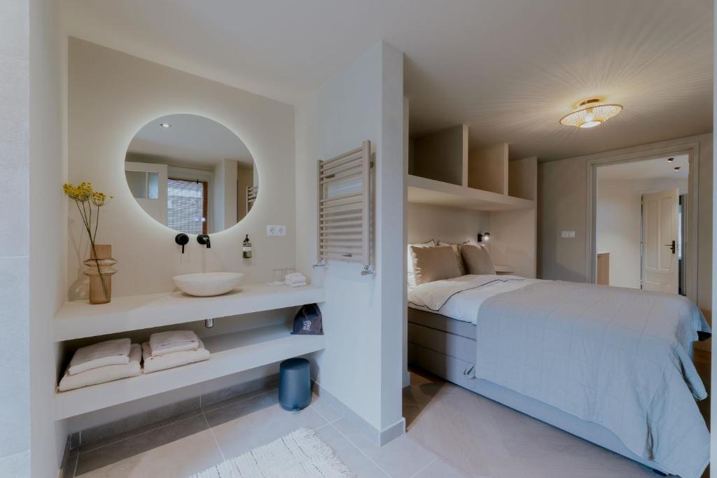 1 dormitorio con cama, lavabo y espejo en Havenhuis studio 1 en Tilburg