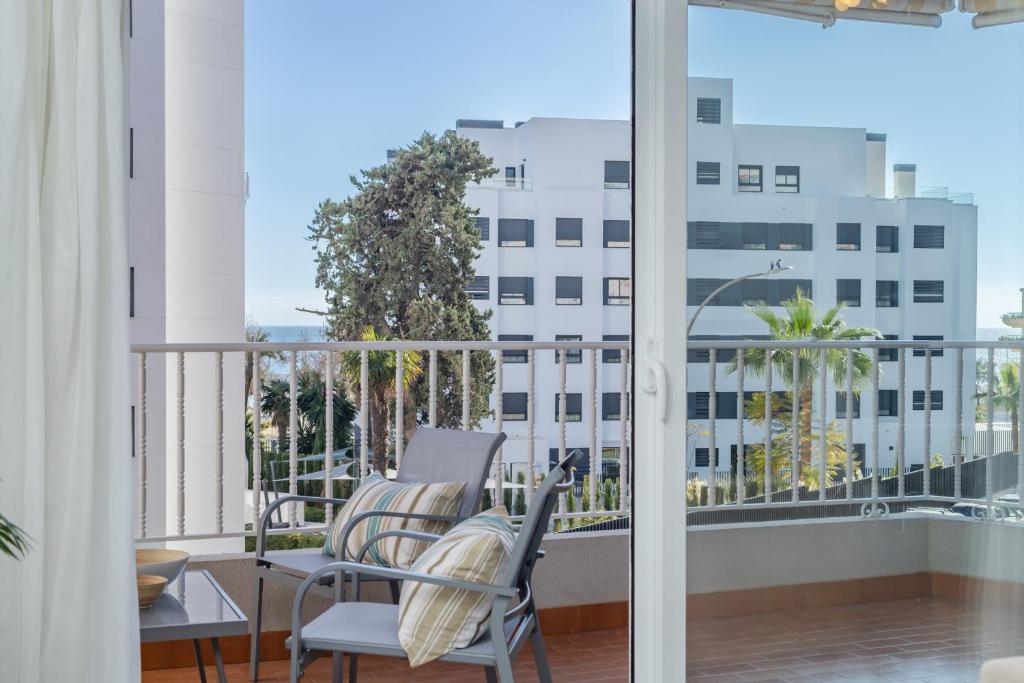 - un balcon avec deux chaises et une vue sur un bâtiment dans l'établissement Barquilla Apartment - Kura Homes, à Marbella