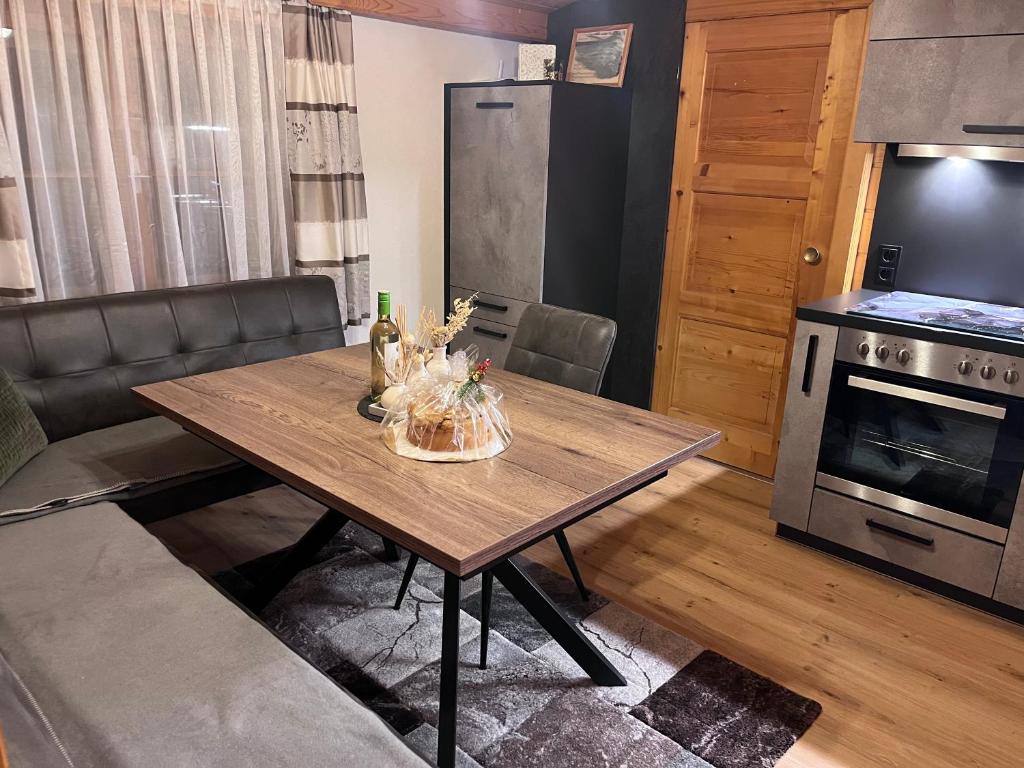 uma sala de estar com uma mesa de madeira e uma cozinha em Ferienwohnung Elisa em Winklern