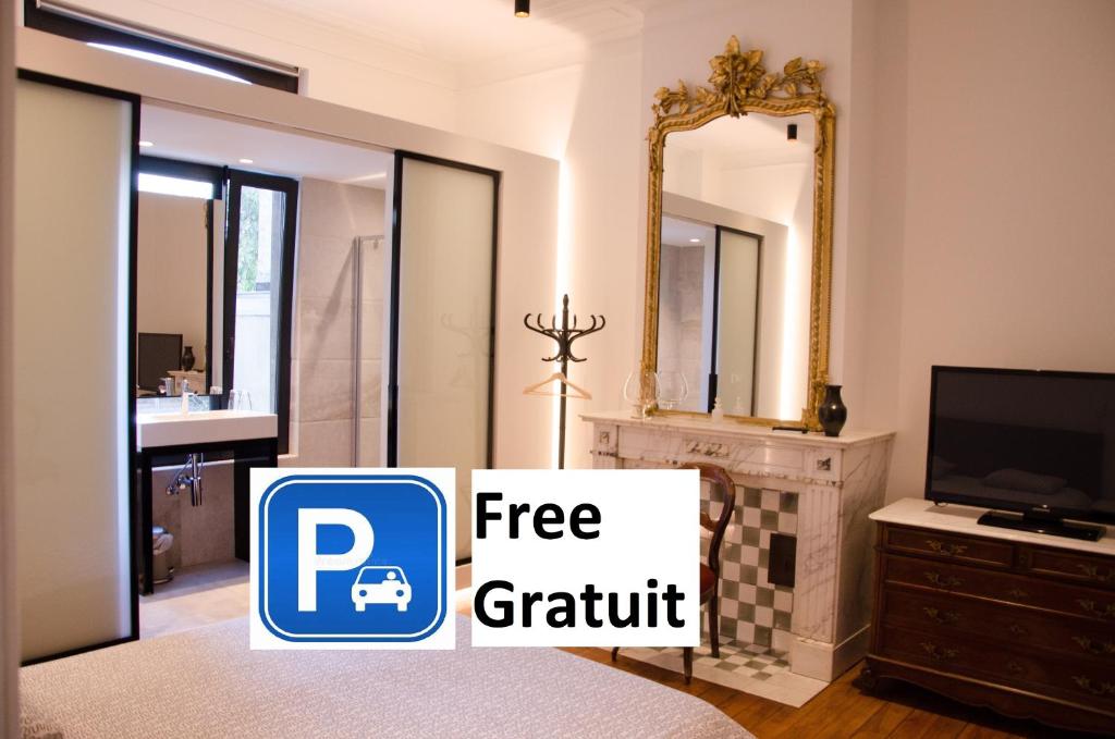 a bedroom with a free gratitude sign in front of a tv at Albert Molière in Brussels