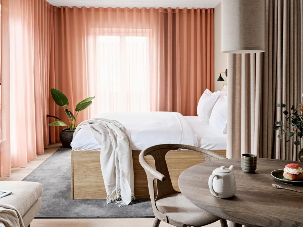 a hotel room with a bed and a table at Aura Apartment Hotel in Aarhus