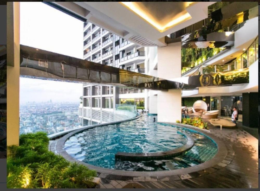 a large swimming pool in the middle of a building at Luxury 2BR Penthouse in Gramercy, Makati in Manila